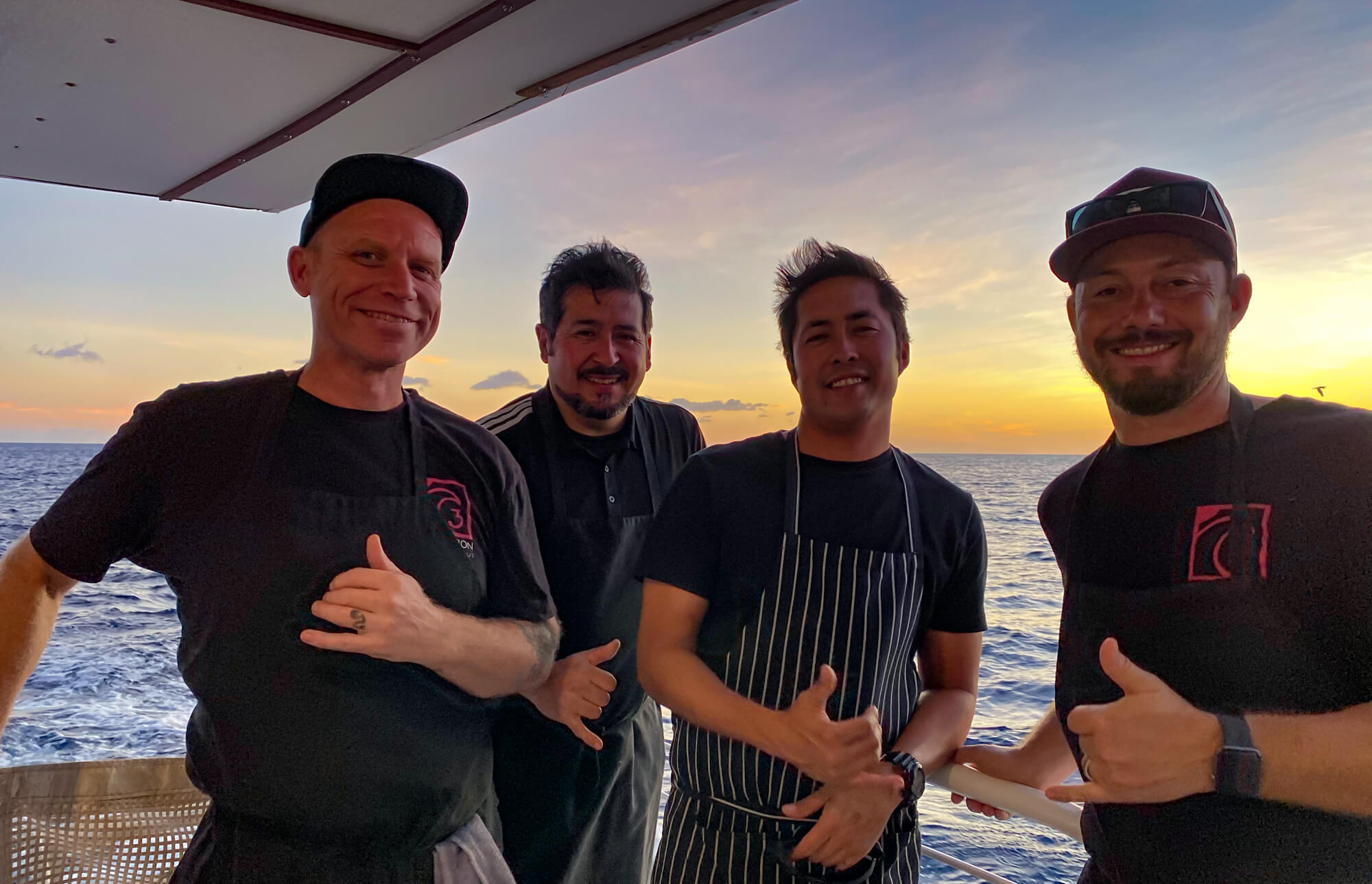 Four chefs on a boat giving thumbs up.
